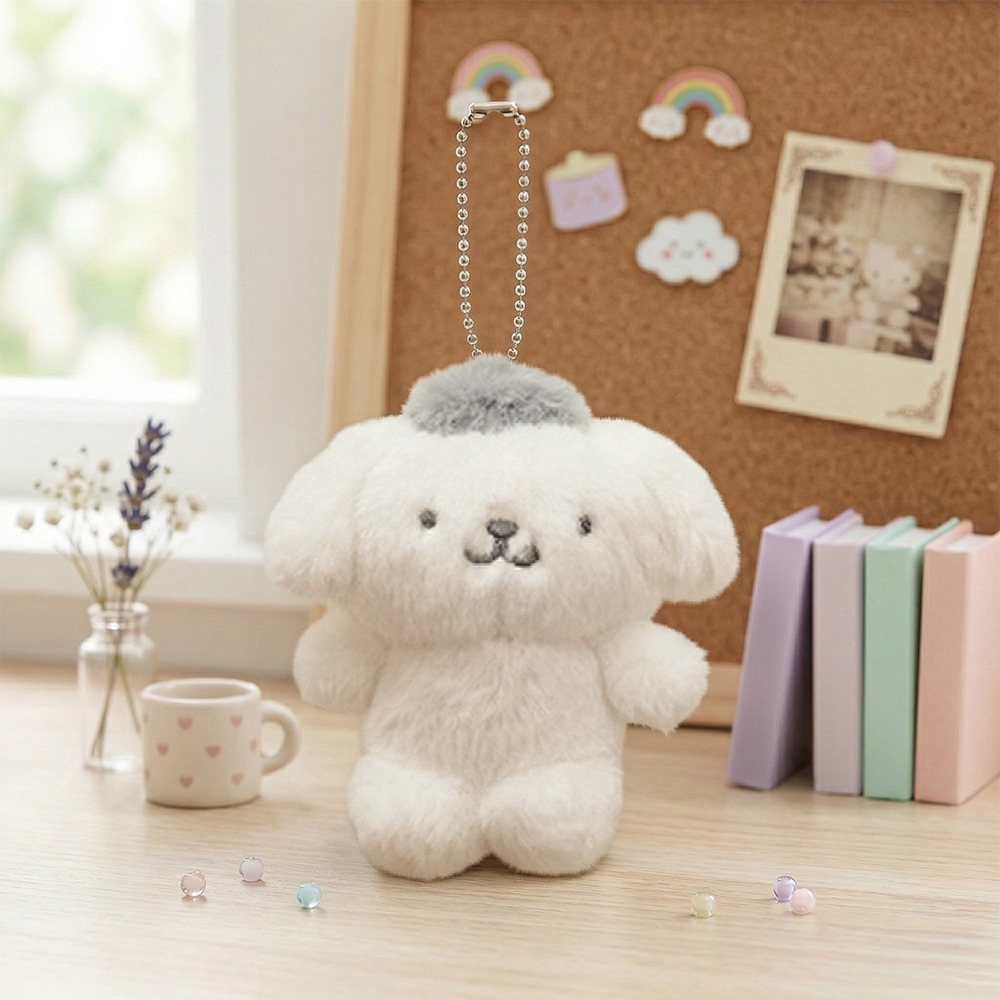 Sanrio Pompompurin Monochrome Plush Mascot Keychain Charm on a desk with stationery and a corkboard.