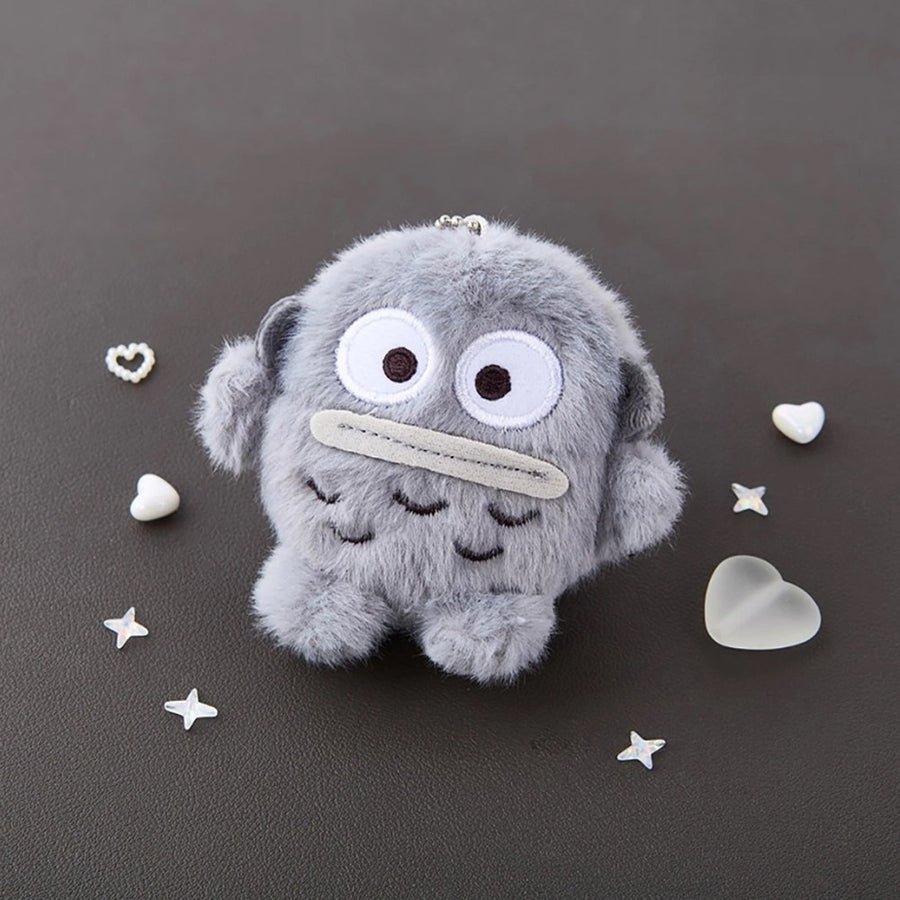 Sanrio Hangyodon Monochrome Plush Mascot Keychain Charm displayed on a dark surface with decorative stars and hearts.