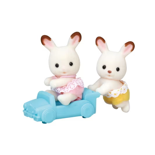 Two rabbit figurines in a blue car on a white background