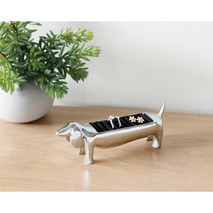 Umbra Dachsie Ring Holder with shiny chrome finish and black ring holder design on wooden surface.