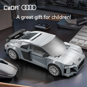 Toy Audi car model on a dark surface with 'CaDA' and 'Audi' branding.