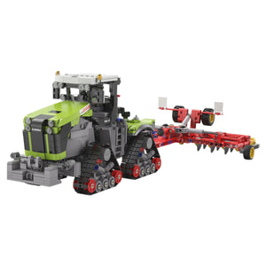 Toy tractor with green and gray body and red attachments on a white background