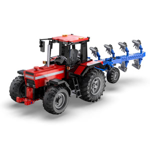 Red and black toy tractor with blue attachment on a white background