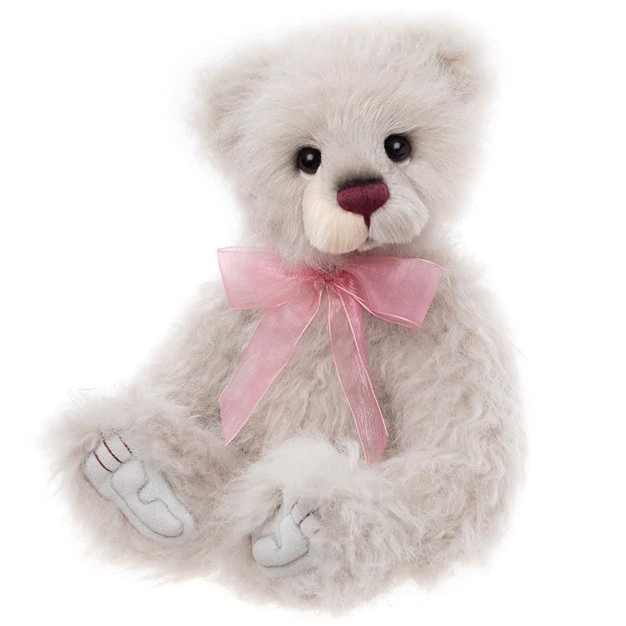 White teddy bear with a pink bow on a white background