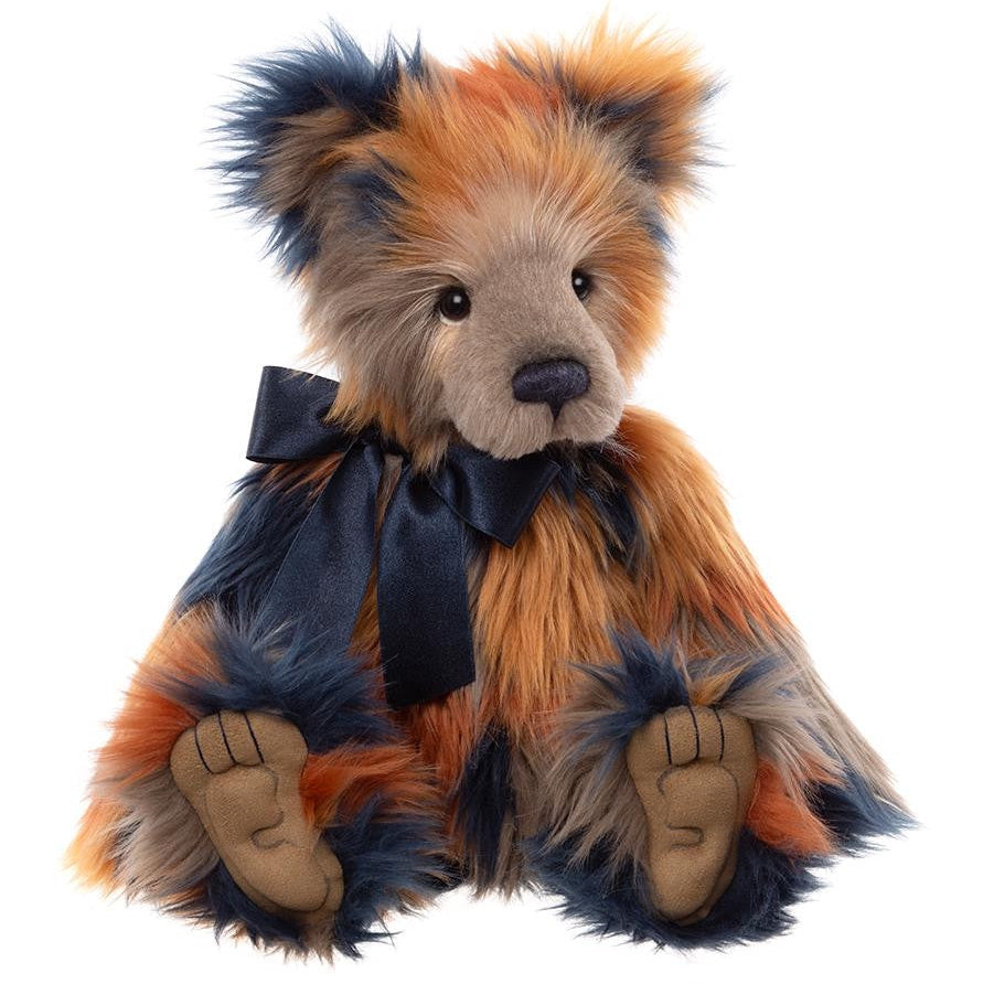 Stuffed teddy bear with orange, blue, and beige fur on a white background