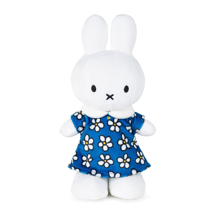 White plush bunny toy wearing a blue dress with white floral patterns on a white background