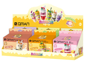 Display of QMAN Build & Fun toy sets with colorful packaging on a white background