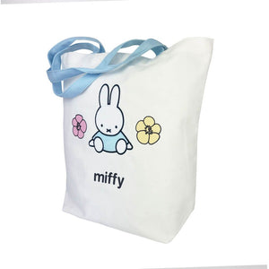 White tote bag with a cartoon character and flowers on a white background