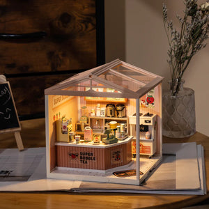Miniature model of a bubble tea shop with interior details on a wooden surface.