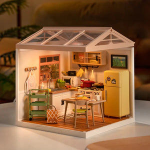 Miniature model of a kitchen with a yellow refrigerator, dining table, and various appliances.