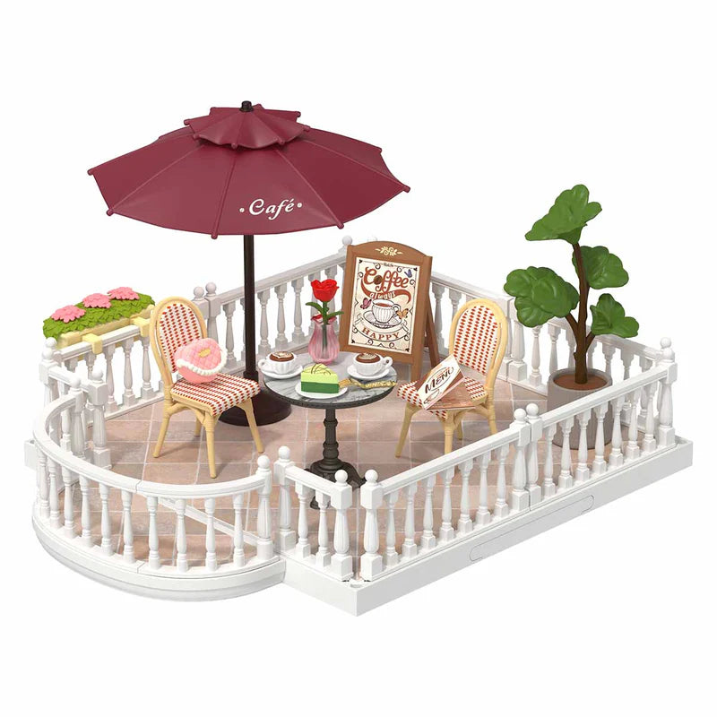 Miniature outdoor cafe set with chairs, table, umbrella, and decorative elements on a white background
