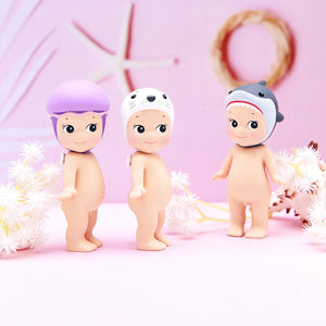 Three baby dolls with colorful hair accessories on a pink background