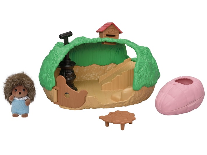 Toy set with a small house, hedgehog figure, and pink pot on a white background