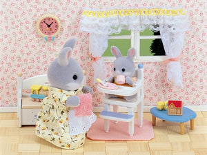 Toy setting with two gray rabbit figures in a room with floral wallpaper and a clock.