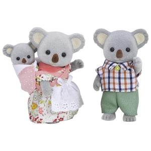 Three toy koalas dressed in colorful outfits on a white background