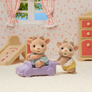 Two toy figures of a mouse and a rabbit sitting on a purple couch in a room with pink furniture and wallpaper.