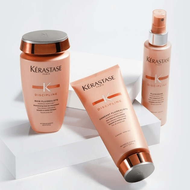 Kérastase Discipline hair care products for frizz control on display, including shampoo, conditioner, and fluid dismiss spray.