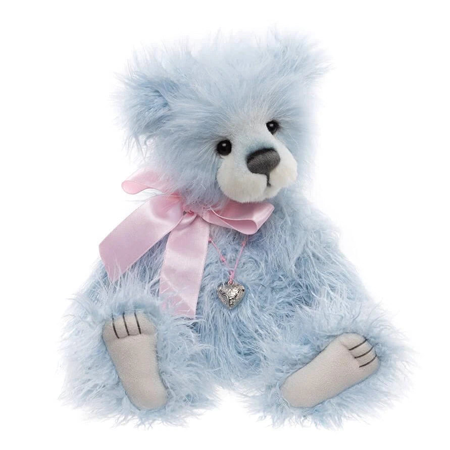 Blue teddy bear with a pink bow and heart charm on a white background