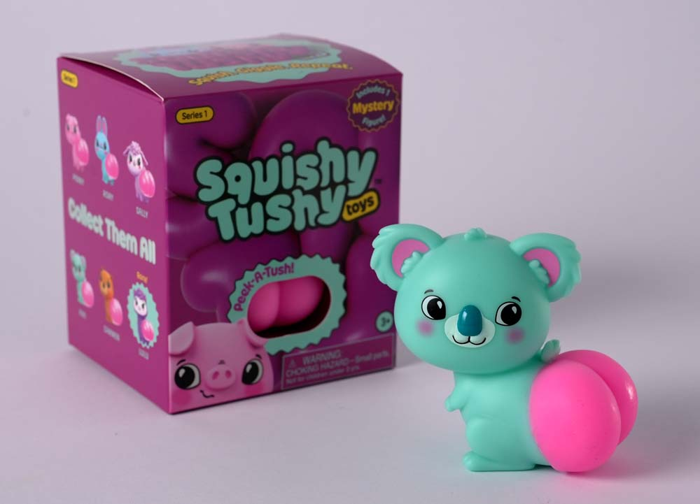 Squishy Tushy Toys Series 1 Blind Box featuring a cute teal koala figure and colorful packaging.