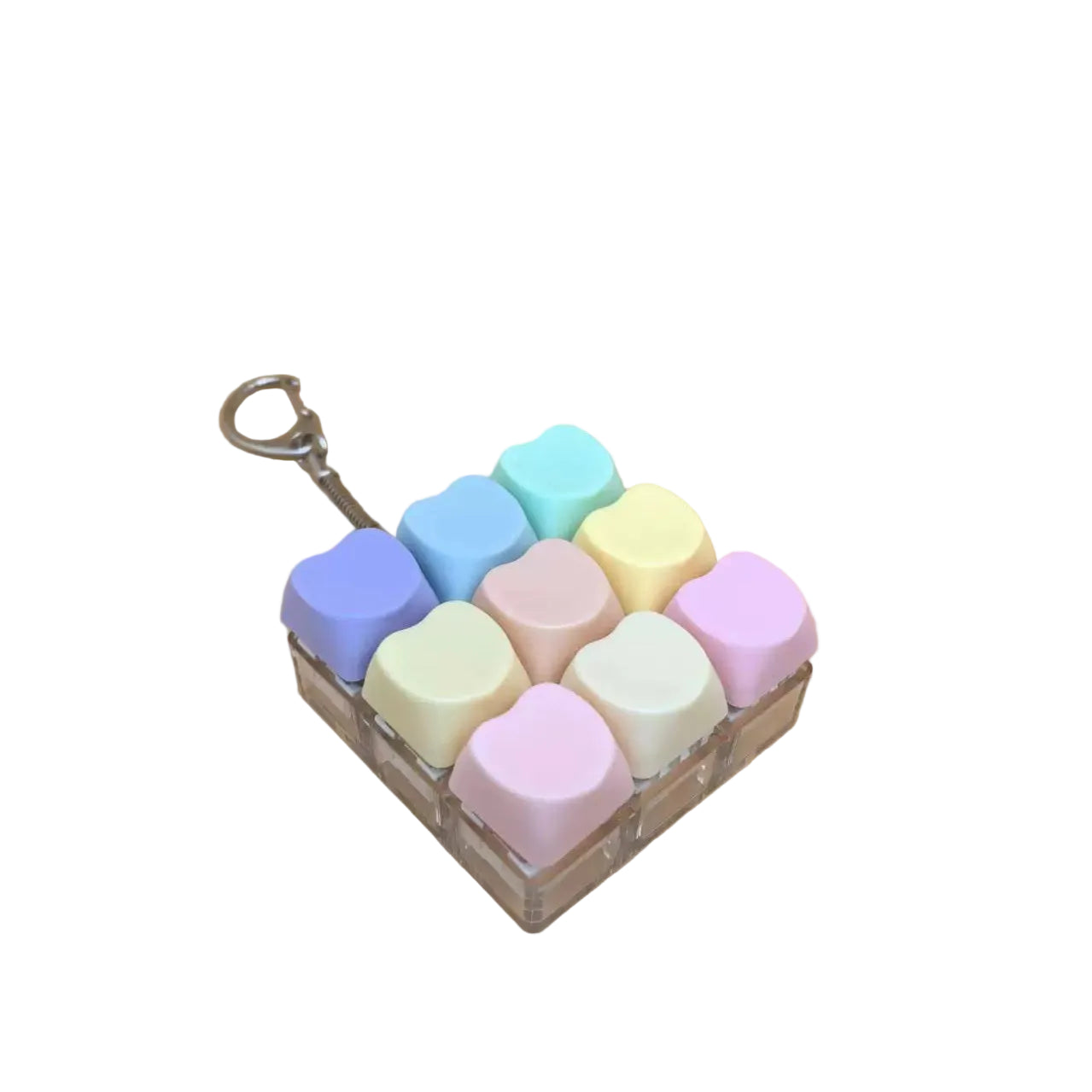 A set of nine pastel-colored, heart-shaped cosmetic caps arranged in a clear square tray with a metal keyring attached, set against a solid beige background.
