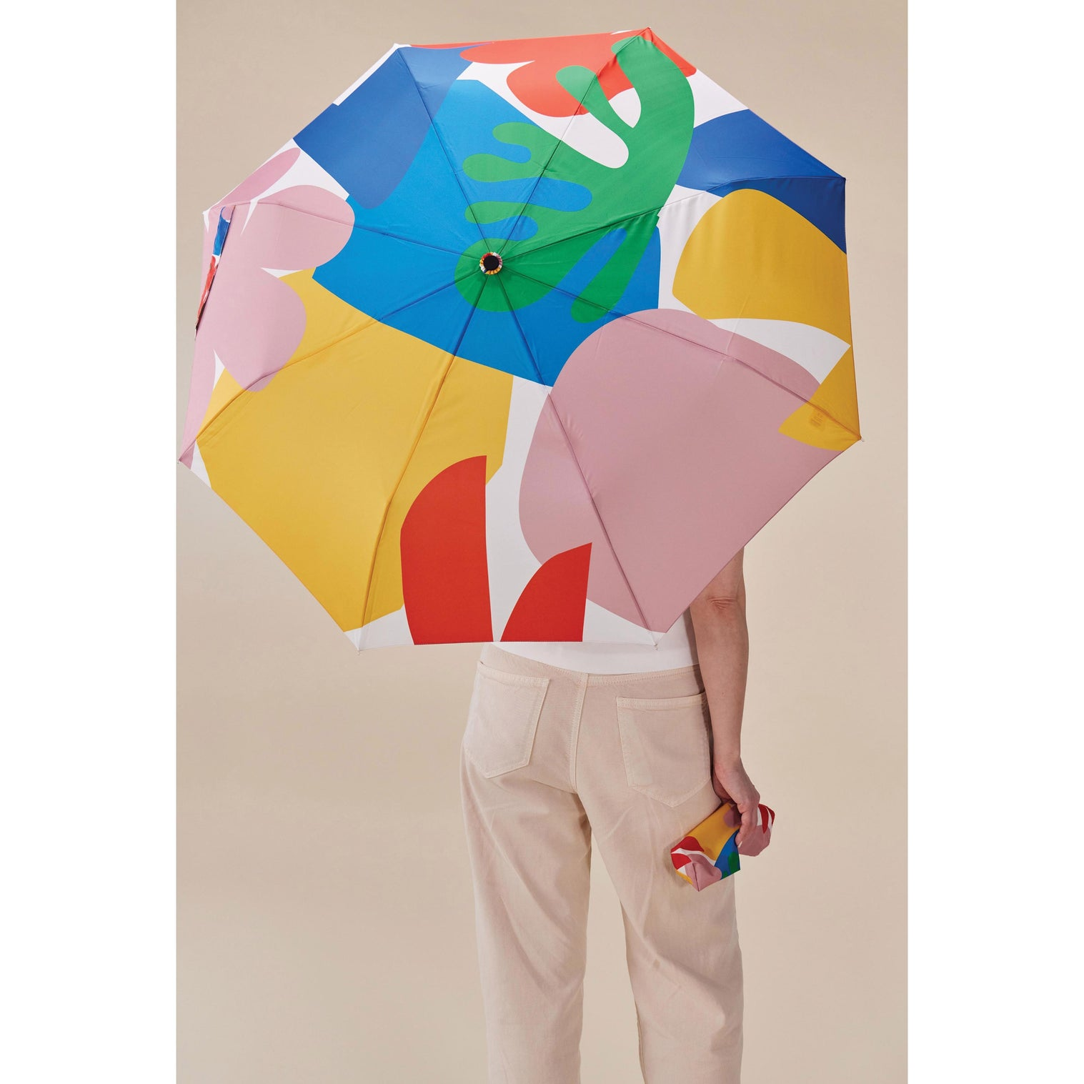 Original DuckHead Duck Umbrella Matisse with colorful print held by a person from behind, ideal for rainy days.