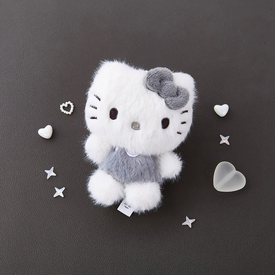 Sanrio Hello Kitty Monochrome Plush Mascot Keychain Charm on a dark background with decorative hearts and stars.