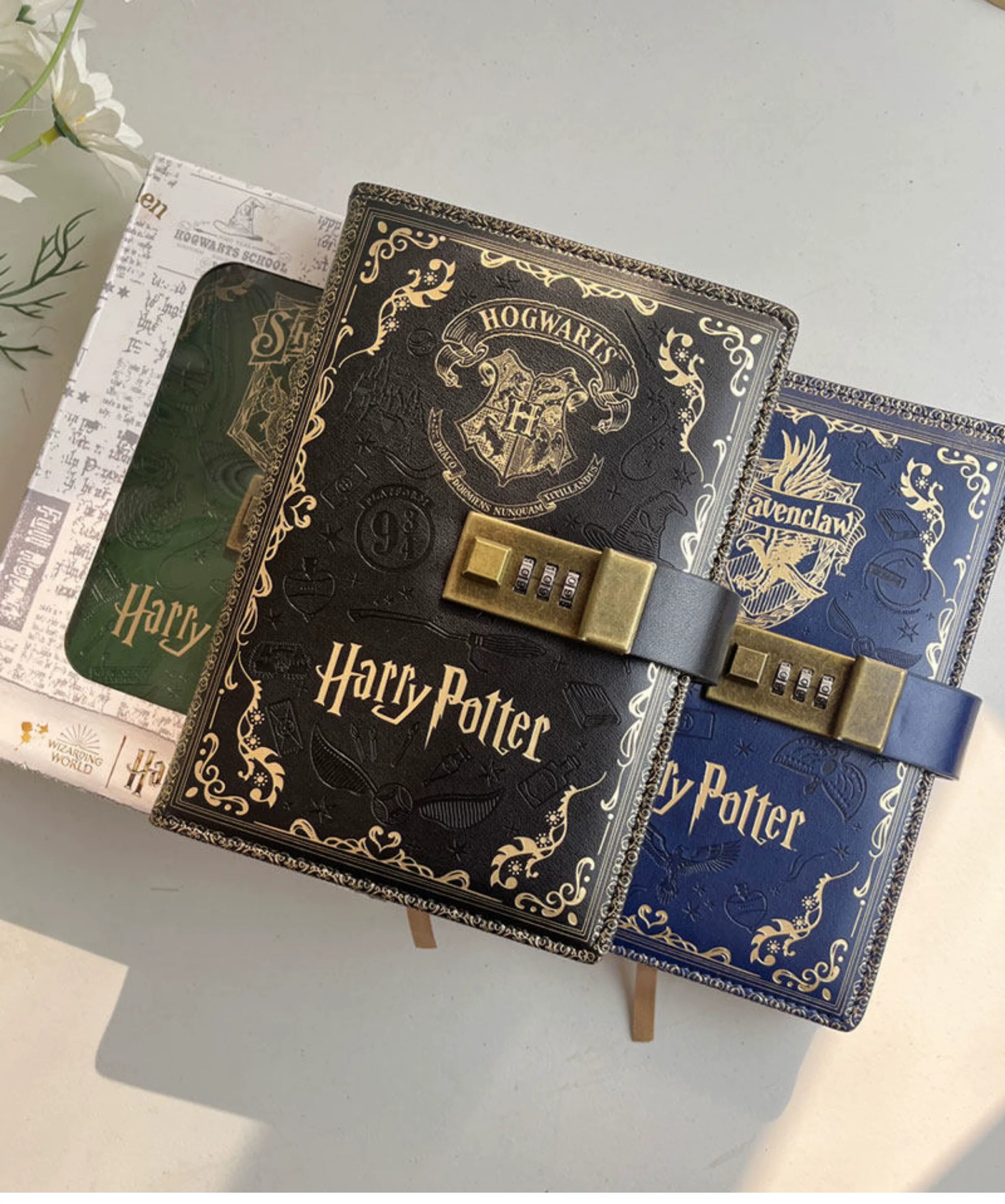 Two Harry Potter-themed lockets with Hogwarts crest on a light surface.
