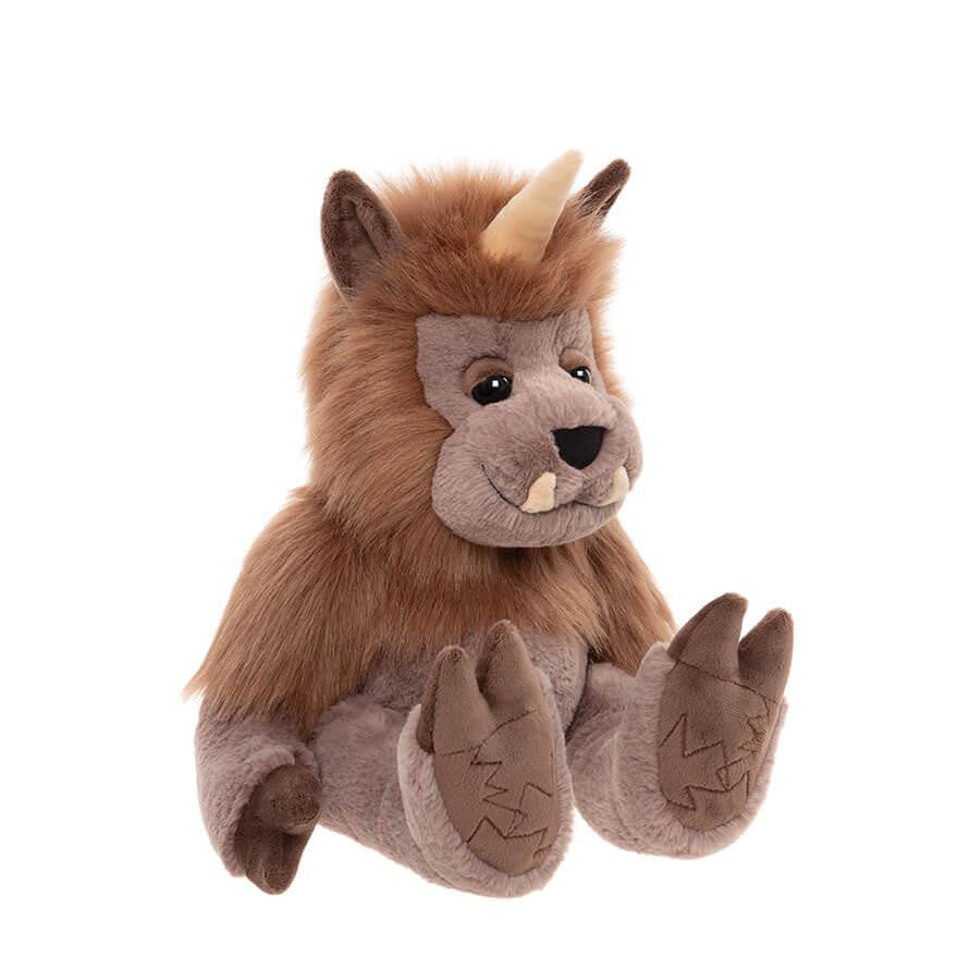 Plush toy resembling a creature with brown fur and horns on a white background
