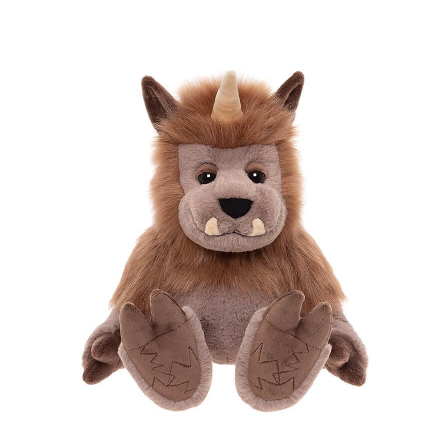 Plush toy resembling a creature with brown fur, black eyes, and a horn on a white background