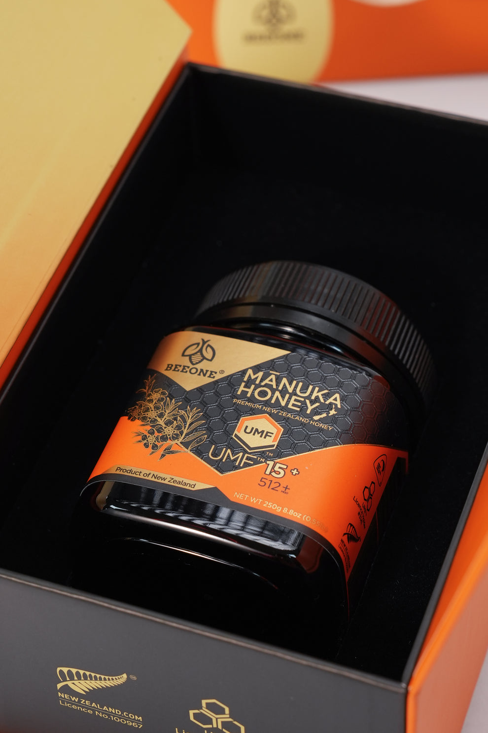 Manuka Honey jar with UMF 15+ on an orange and black background