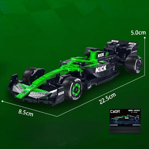 Green and black toy Formula 1 car with measurements on a green background