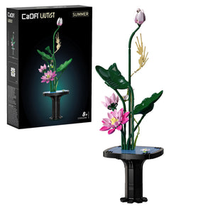 Model of a flower arrangement with a black stand next to its packaging
