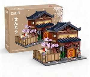 Model of a traditional Japanese building with cherry blossoms and a CaoR box in the background.