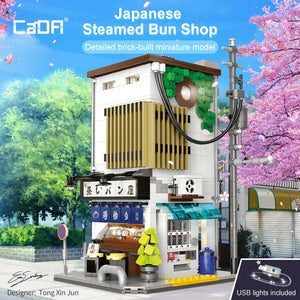 Detailed brick-built miniature model of a Japanese steamed bun shop with cherry blossoms in the background.