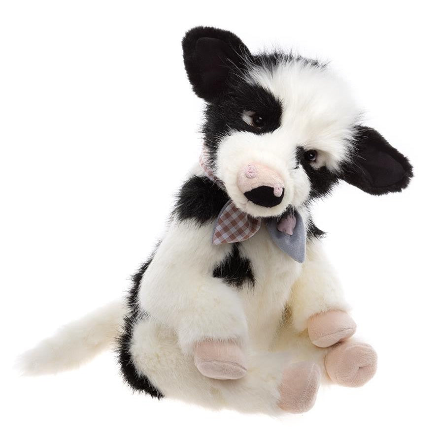 Black and white stuffed dog toy with a bow tie on a white background