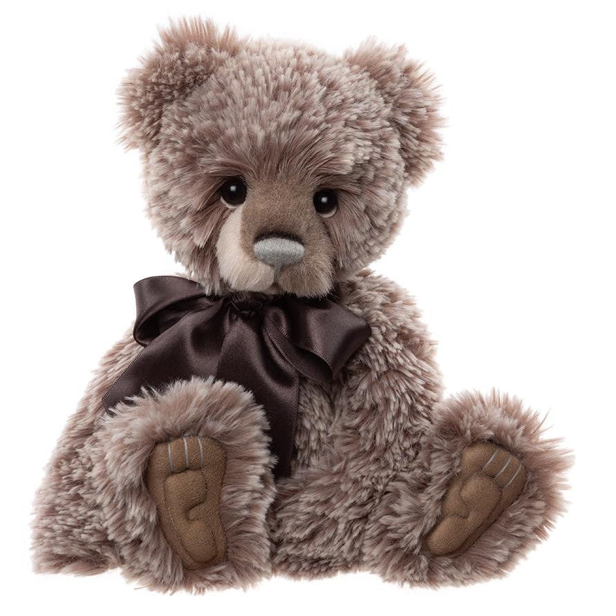 Plush teddy bear with a brown bow tie on a white background