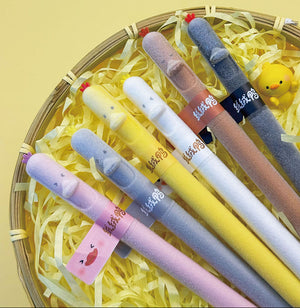 Six novelty felt pens in pastel colors arranged in a round basket filled with yellow shredded paper, with Chinese promotional text at the top.
