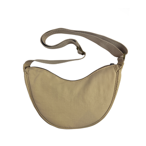 Beige crossbody bag with a strap on a white background