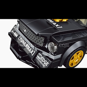 Close-up of a black toy car with gold accents and 'Tunermax' branding on a white background.