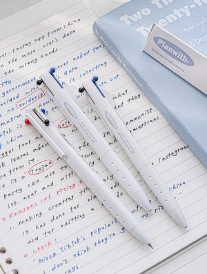 Set of pens with colored tips on a notebook page, with a book titled 'Two The Twenty' and a box labeled 'Planwith' in the background.
