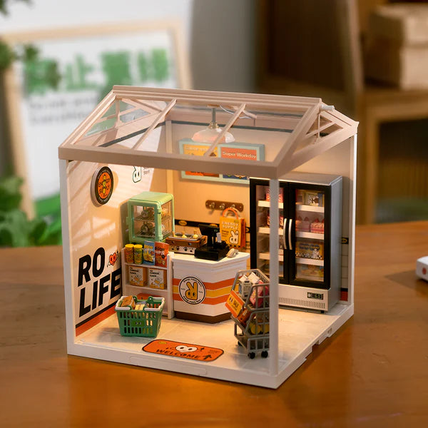 Miniature model of a grocery store with 'RO LIFE' branding on a wooden surface.