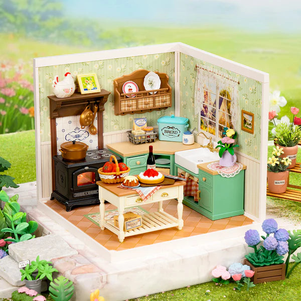 Miniature model of a kitchen with various items and plants in an outdoor setting