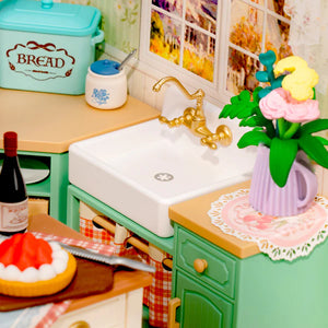 Miniature kitchen setup with sink, cabinets, and decorative elements.