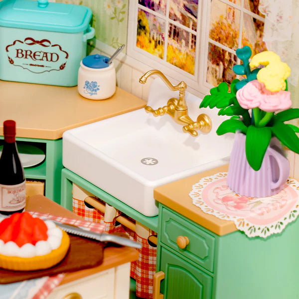 Miniature kitchen setup with sink, cabinets, and decorative elements.