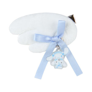 White cloud-shaped pillow with a blue ribbon and bear charm on a white background