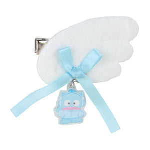 Hair clip with white wings, blue ribbon, and a small cartoon character on a white background