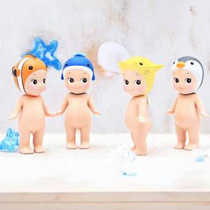 Four baby dolls with colorful hats on a light background