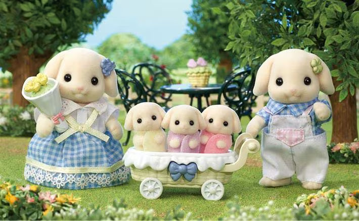 Toy figures of a family with a baby carriage in a garden setting