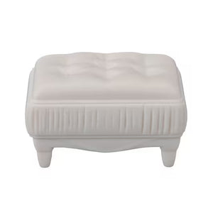 White ottoman with tufted design on a white background