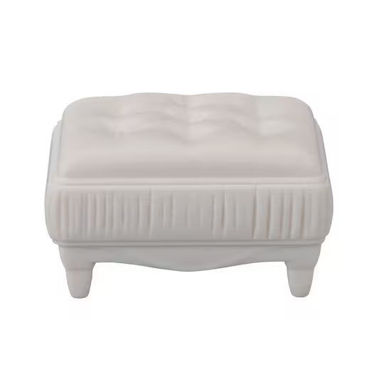 White ottoman with tufted design on a white background